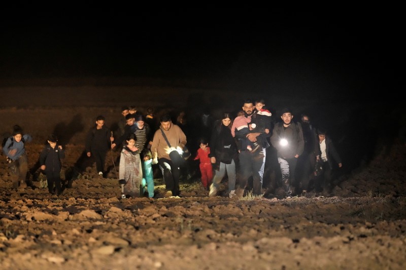 Detained migrants walk next to the Belarus-Latvia border near Vorzova