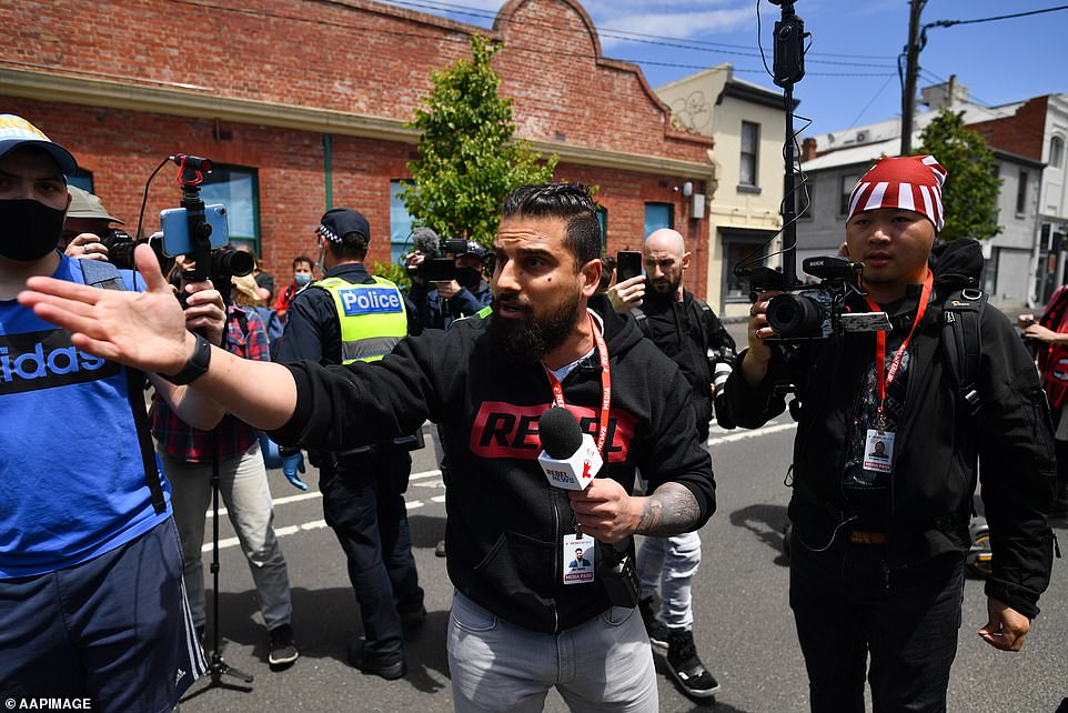 YouTuber Avi Yemini speaks with police during the anti-vaccination rally in Melbourne on Saturday