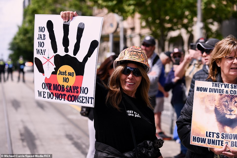 Protester wearing a decorated mining hit and holding up a banner at the Melbourne rally