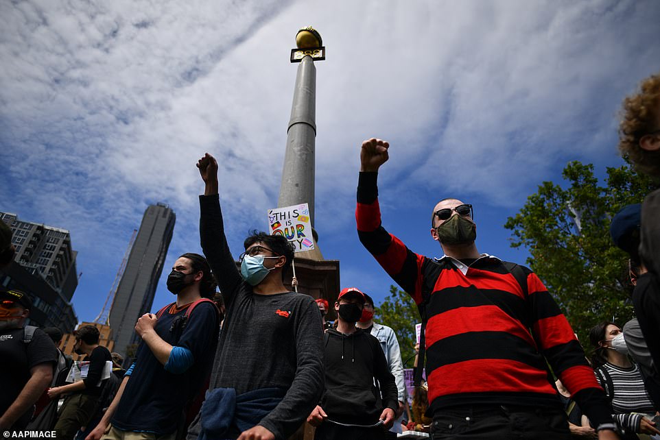 Protesters raise their fists in solidarity during the 'freedom' rally in Melbourne on Saturday