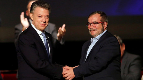 Colombia's President Juan Manuel Santos and Marxist FARC rebel leader Rodrigo Londono, known as Timochenko, shake hands after signing a peace accord in Bogota, Colombia November 24, 2016 © Jaime Saldarriaga