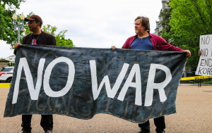 Christopher Glenn and Kevin Zeese holding No War banner at White House and Eisenhower Executive Office Building April 27,  2017. Photo by Anne Meador, DC Media Group.