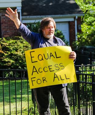 Kevin Zeese protesting outside of Ajit Pai home on May 14, 2017. By Anne Meador of DC Media Group.