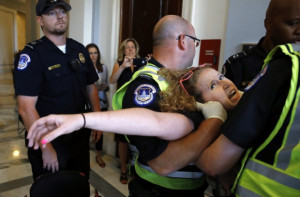 Stephanie Woodward, of Rochester, NY, who has spina bifida and uses a wheelchair, is removed from a sit-in at Senate Majority Leader Mitch McConnell’s office as she and other disability rights advocates protest proposed funding caps to Medicaid, Thursday, June 22, 2017, on Capitol Hill in Washington. CREDIT: AP Photo/Jacquelyn Martin