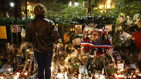 A woman looks at flowers, candles and messages in tribute to victims near the Bataclan concert hall in Paris, France, November 20, 2015. © Charles Platiau