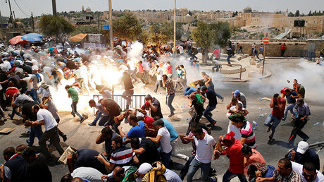 Palestinians react following tear gas that was shot by Israeli forces after Friday prayer on a street outside Jerusalem's Old city July 21, 2017. © Ammar Awad