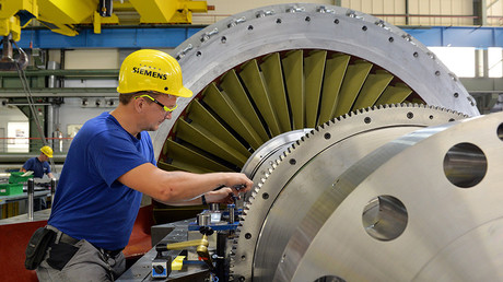 A Siemens worker monitors a turbine in the final assembly stage © Maurizio Gambarini / Global Look Press