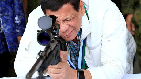 Philippines President Rodrigo Duterte checks the scope of a 7.62mm sniper rifle © Romeo Ranoco