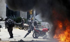 Venezuela_2017_Police officer burns motorbike