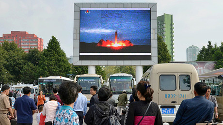 North Koreans watch a news report showing North Korea's Hwasong-12 intermediate-range ballistic missile launch on electronic screen at Pyongyang station in Pyongyang, North Korea August 30, 2017 © Kyodo 