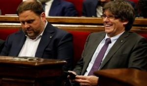 President of the Catalan Government Carles Puigdemont (right) laughs beside Catalan regional vice-president Oriol Junqueras during a session at the Catalan parliament to debate and vote a secession law, in Barcelona, on September 7