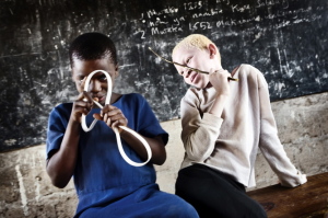 Selina, right, and her friend Mwanaidi play together in a Tanzanian classroom. Children with albinism are very vulnerable to attack, mutilation and murder. Courtesy EPA/Johan Baevman