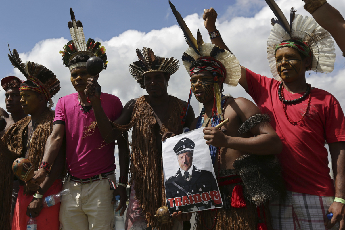Indigenous protesters hold a poster depicting Brazil's President Michel Temer as Nazi leader Adolf Hitler with the Portuguese word "Traitor" in Brasilia, Brazil, Friday, April 28, 2017. (AP/Eraldo Peres)