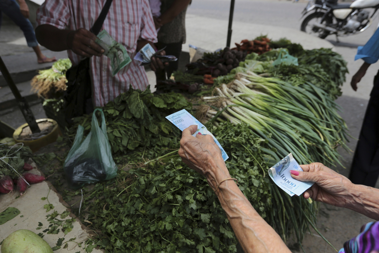 In this Sept. 23, 2017 photo, customers pay with new bank notes for their groceries, at a market in Caracas, Venezuela. (AP/Fernando Llano)