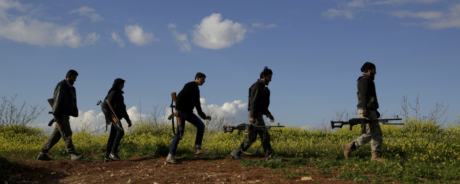 Fighters from the Ahrar al-Sham carry their weapons as they move towards their positions near the Morek frontline in the northern countryside of Hama, Syria, March 16, 2015. (Khalil Ashawi/Reuters)