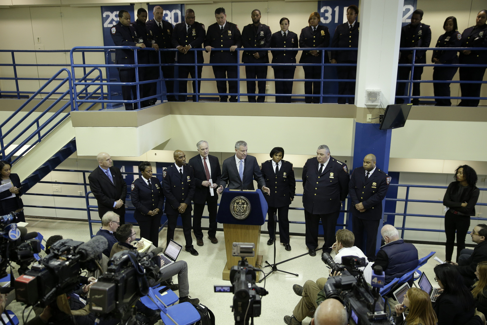 Surrounded by corrections officers, New York City Mayor Bill de Blasio holds a news conference on Rikers Island in New York, March 12, 2015. The mayor unveiled a plan to curb jail violence after a visit to the problem-plagued Rikers Island jail complex. (AP/Seth Wenig)