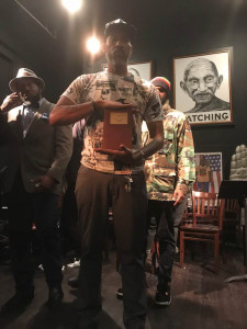 Kymone Freeman in December 2017 holding 1910 history book of John Brown after reading of his play Patriotic Treason in Washington, DC. 