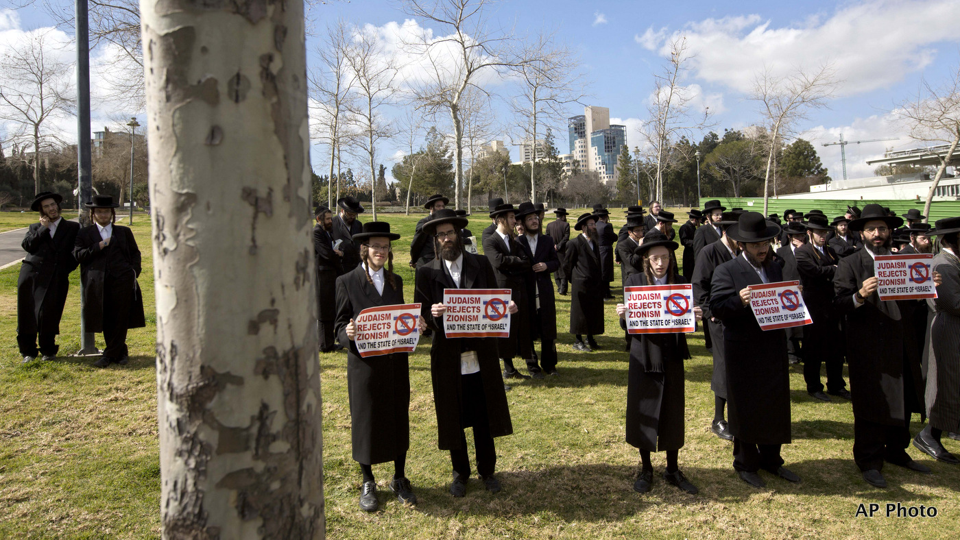 Members of the anti-Zionist ultra-Orthodox Neturei Karta group, a group that opposes Zionism and the Israeli state, hold signs during a demonstration against Prime Minister Benamin Netanyahu's U.S. visit, in front of the U.S. consulate in Jerusalem. March 3, 2015. (AP/Sebastian Scheiner)