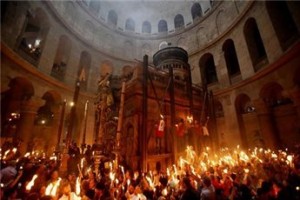Christian worshipers hold up candles lit from the 'Holy Fire' as thousands gather for the 'Holy Fire' ceremony at the Church of the Holy Sepulchre in Jerusalem's Old City, on April 19, 2014 (AFP Gali Tibbon)