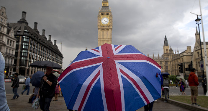 A pedestrian shelters from the rain beneath a Union flag themed umbrella as they walk near the Big Ben clock face and the Elizabeth Tower at the Houses of Parliament in central London. (File)