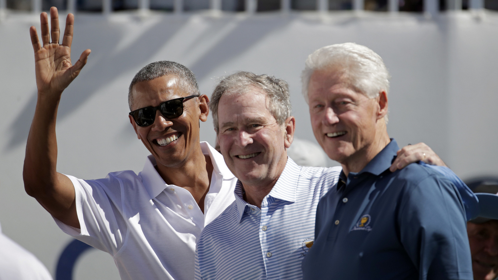 Former U.S. Presidents, from left, Barack Obama, George Bush and Bill Clinton greet spectators on the first tee before the first round of the Presidents Cup at Liberty National Golf Club in Jersey City, N.J., Sept. 28, 2017. (AP/Julio Cortez)