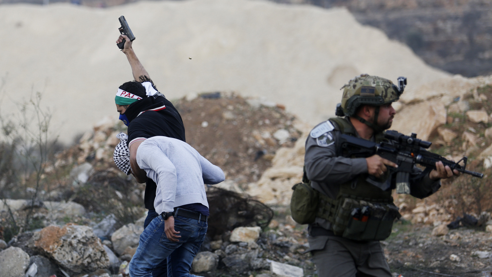 An Israeli policeman disguised as a Palestinian protester raises a pistol in air as he arrests a Palestinian demonstrator during protests against U.S. President Donald Trump's decision to recognize Jerusalem as the capital of Israel, in the West Bank city of Ramallah, Dec. 13, 2017. (AP/Nasser Shiyoukhi)
