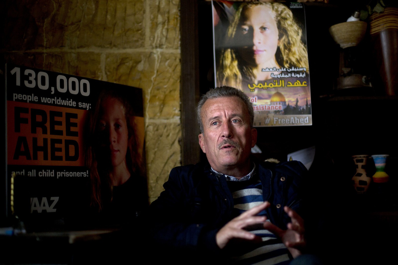 Bassem Tamimi speaks in front of a poster showing his daughter Ahed at his home in Nabi Saleh near the West Bank city of Ramallah. Israel's hard-charging prosecution of his 16-year-old daughter who slapped two Israeli soldiers has trained a spotlight on her family and its role in near-weekly protests against Israeli occupation staged in several West Bank cities. (AP/Majdi Mohammed)