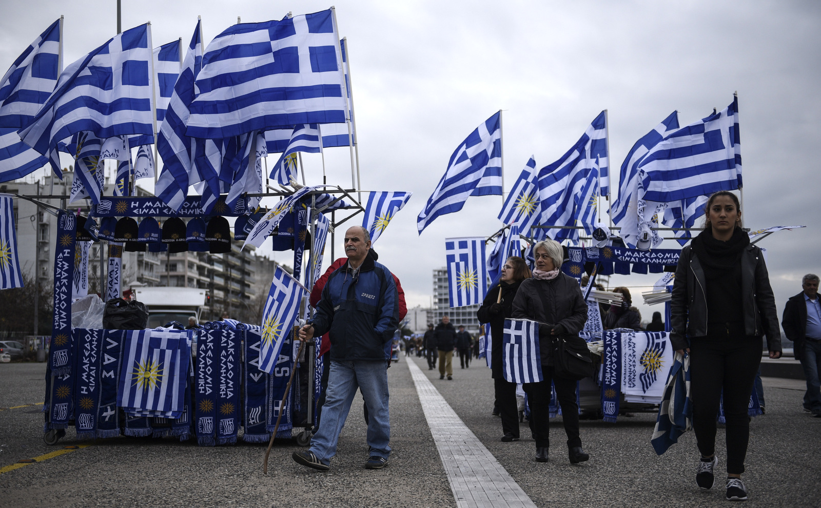 People walk between Greek flags ahead of a rally against the use of the term "Macedonia" for the northern neighbouring country's name, at the northern Greek city of Thessaloniki, Jan. 21, 2018.(AP/Giannis Papanikos)