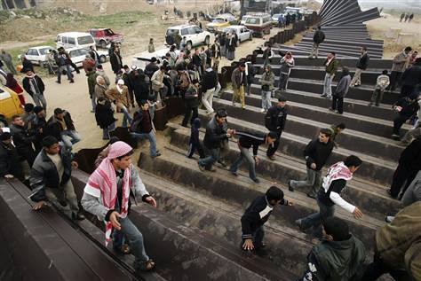 Image: Palestinians cross the Rafah border into Egypt.