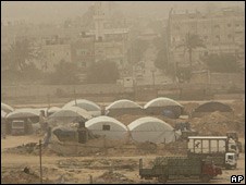 Lorries wait to load goods from the tent-covered smuggling tunnels in Rafah. Photo: April 2010