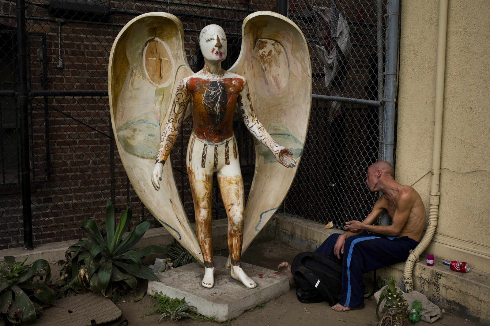 Homeless drug addict Andrew Hudson, 33, injects himself with heroin next to an angel statue, Nov. 8, 2017, in the Skid Row area of downtown Los Angeles. "It's miserable quitting, or trying - trying anything," said Hudson. Skid Row is home to thousands of chronically homeless people on the edge of the downtown. (AP/Jae C. Hong)