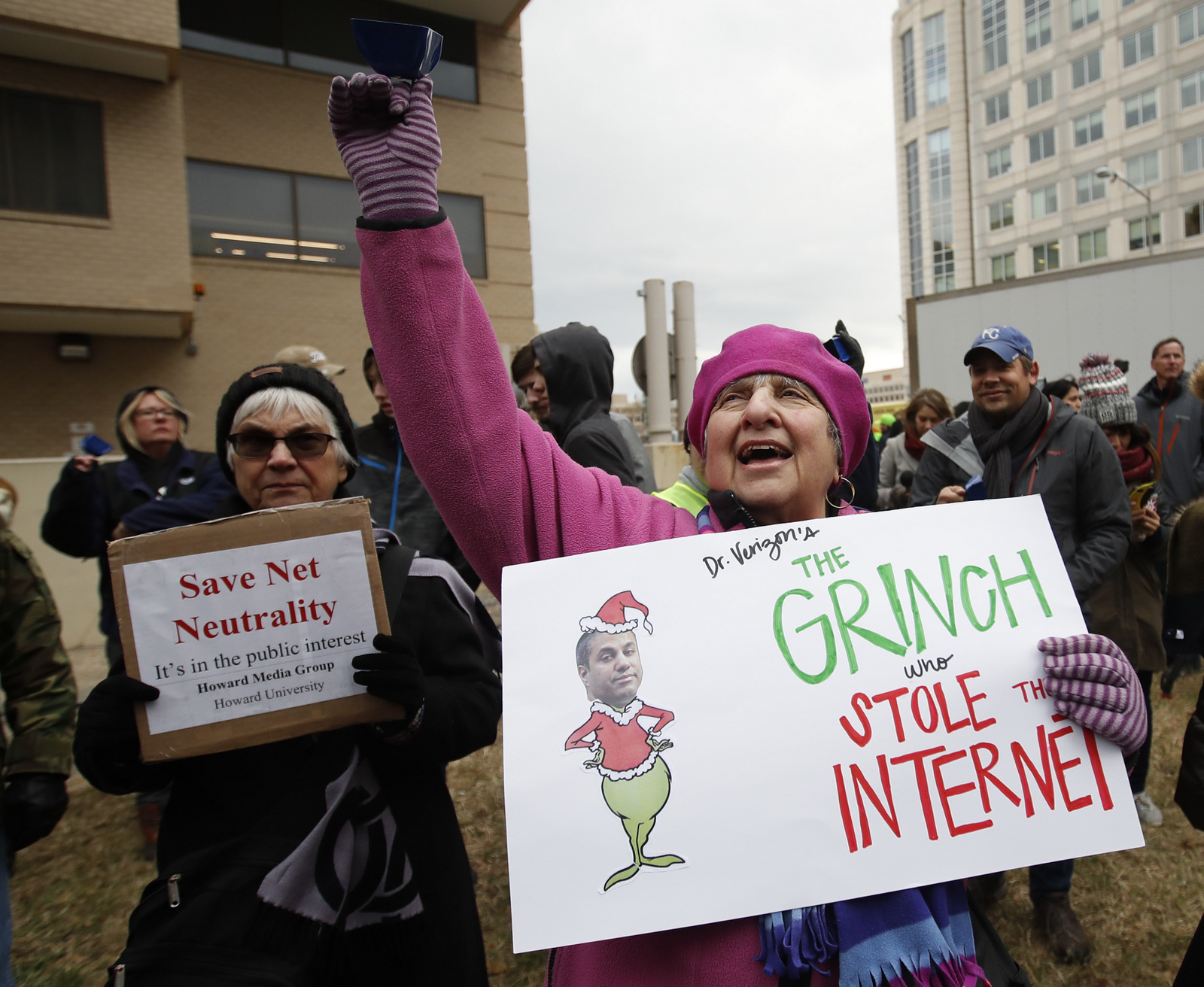 Diane Tepfer holds a sign with an image of Federal Communications Commission (FCC) Chairman Ajit Pai as the "Grinch who Stole the Internet" as she protests near the FCC, in Washington, Dec. 14, 2017. (AP/Carolyn Kaster)