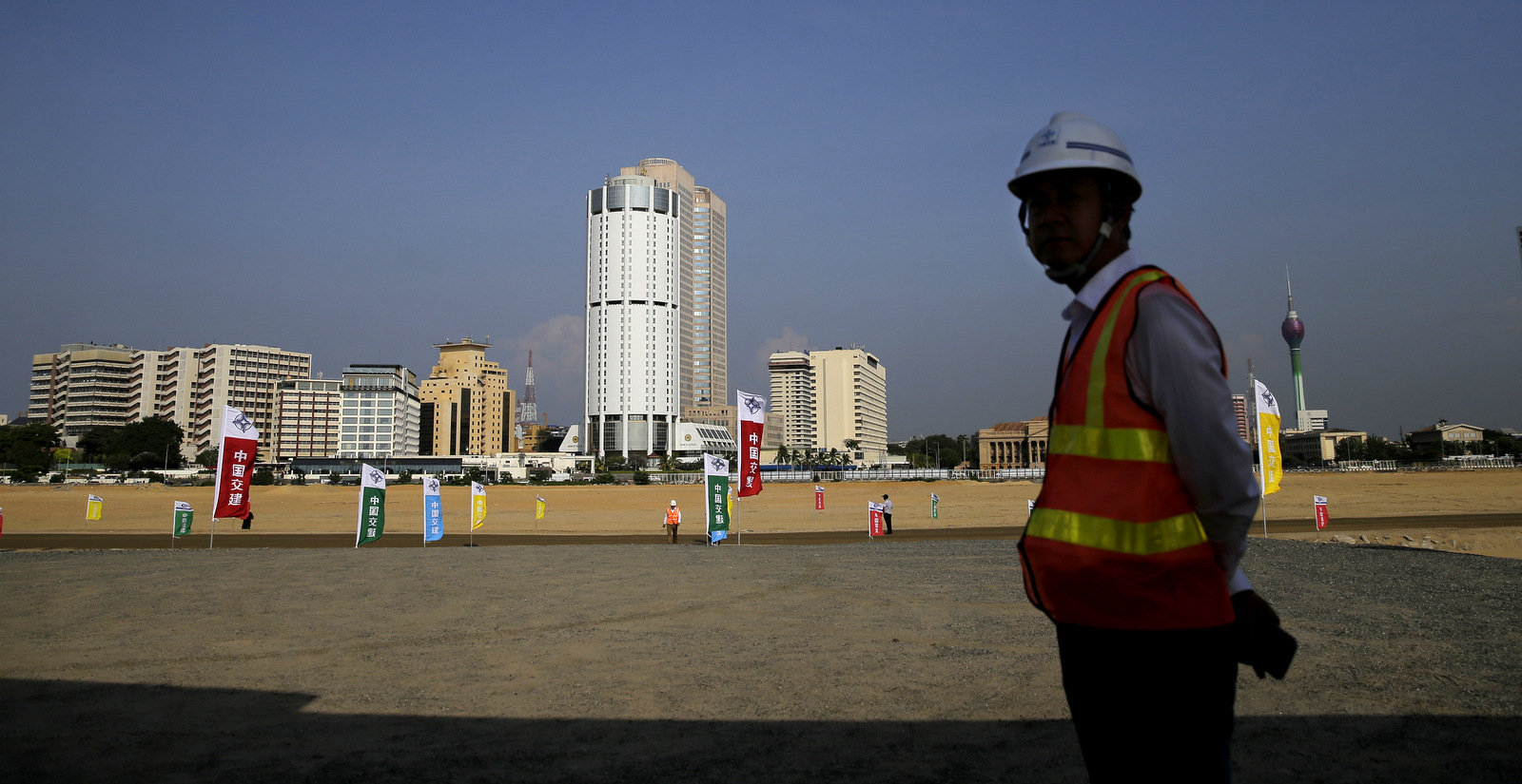A Chinese construction worker stands on the land that was reclaimed from the Indian Ocean for the Colombo Port City project, on the Galle Face sea promenade in Colombo, Sri Lanka, Jan. 2, 2018. The Port City project was initiated as part of China's ambitious One Belt One Road initiative which envisages linking China's economic centers with energy-rich Persian Gulf along the ancient silk road. (AP/Eranga Jayawardena)