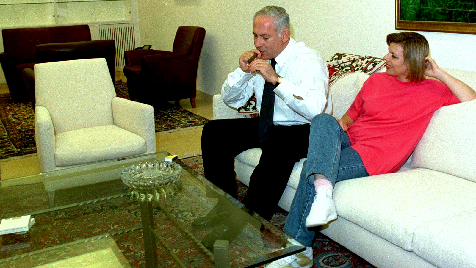 Sarah Netanyahu watches her husband, Israeli Prime Minister Benjamin Netanyahu, light a cigar in the living room of their newly refurbished official residence in Jerusalem Sunday Sept 28 1997. (AP/Zoom 77)