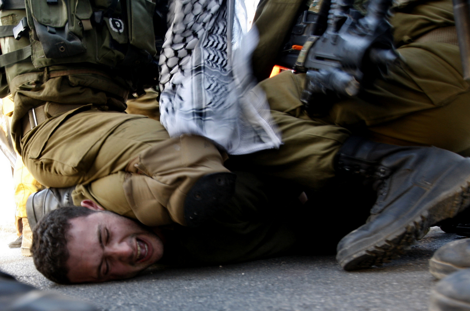A Palestinians activist is detained by Israeli soldiers during a protest against the Prawer Plan to resettle Israel’s Palestinian Bedouin minority near the Israeli settlement of Bet El, north of Ramallah, Nov. 30, 2013. (AP/Majdi Mohammed)
