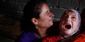 Mother holding daughter during FGM procedure in Egypt, Aug 2015.