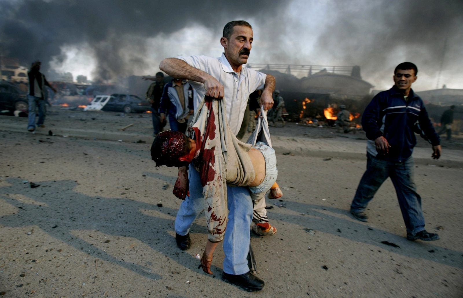 An Iraqi man holds the body of a boy after a car bomb explosion at a market in the neighborhood known as New Baghdad, southeast of Baghdad February 18, 2007. (Carlos Barria/Reuters) 