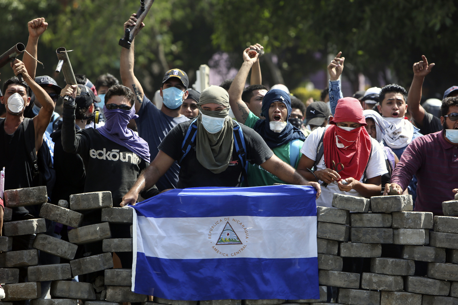 Masked protesters yell from the road block they erected as they face off with security forces near the University Politecnica de Nicaragua (UPOLI) in Managua, Nicaragua, April 21, 2018. (AP/Alfredo Zuniga)