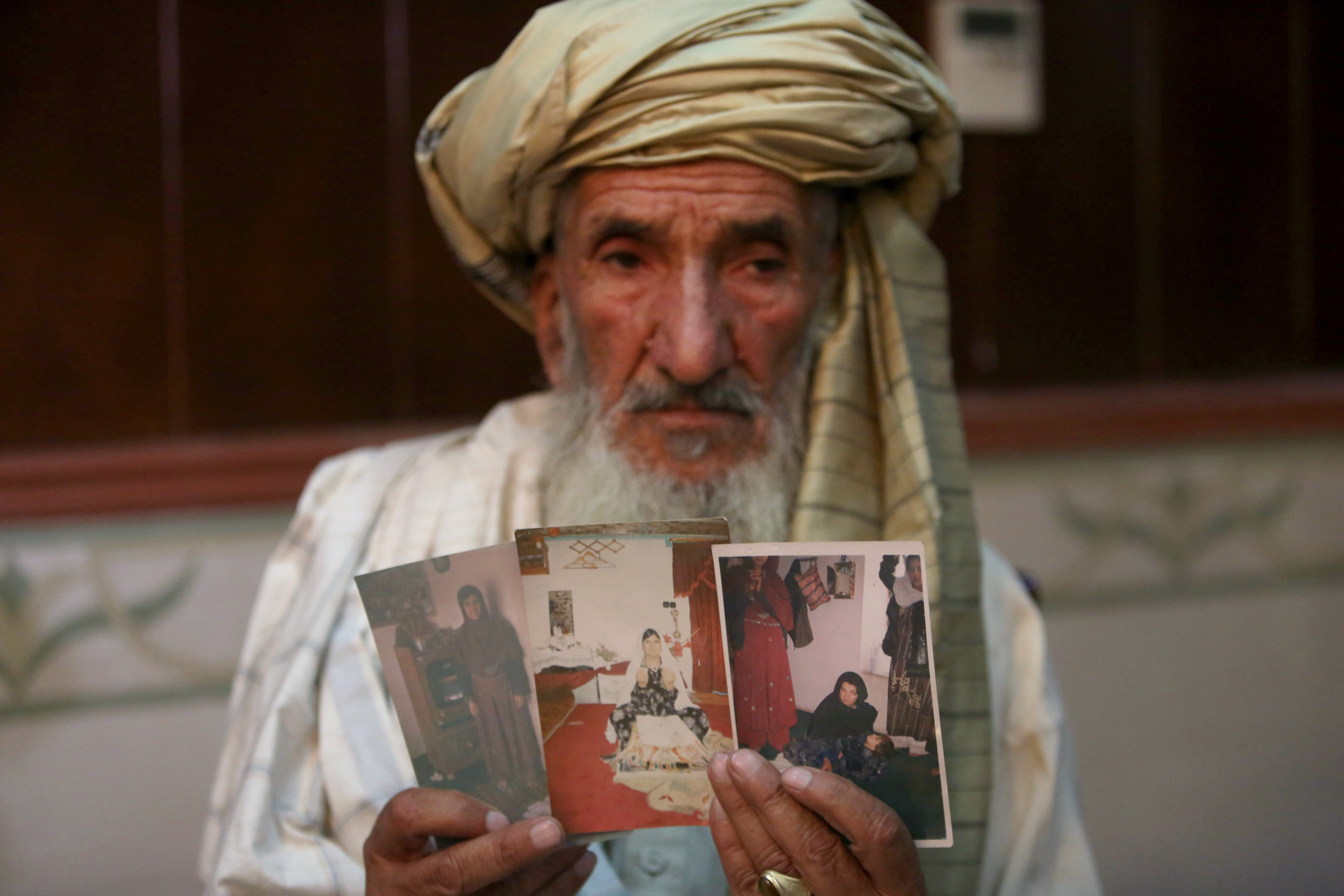 Hajji Sharfddin 67,holds photographs of relative, who went missing during U.S. military operations in Gardez province, east of Kabul, Afghanistan, Aug. 11, 2014. (AP/Rahmat Gul)