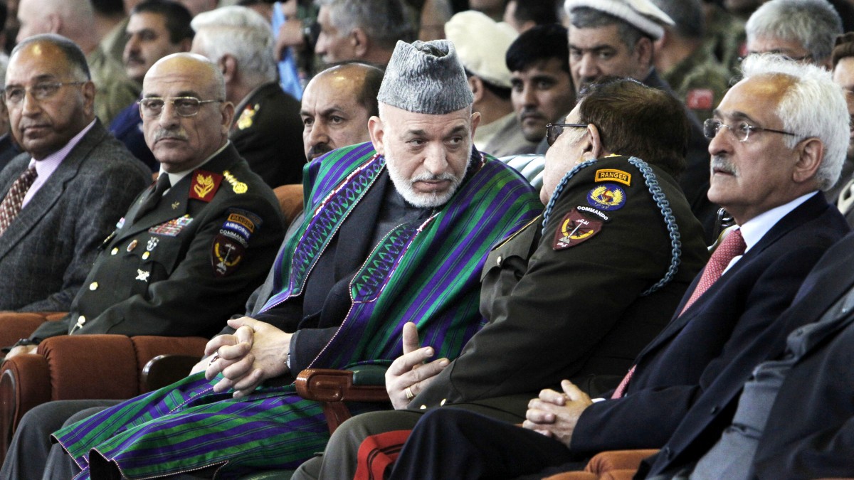Afghan President Hamid Karzai, center, listens to Defense Minister Abdul Rahim Wardak, unseen, during a graduation ceremony of Afghan military officers in Kabul, Afghanistan, Thursday, March 22, 2012. Afghanistan's president said Thursday that his government is "taking a magnifying glass" to proposals for the country's strategic partnership deal with the United States and scrutinizing every detail. (AP Photo/Musadeq Sadeq)