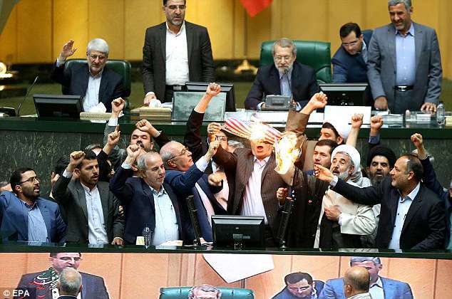Iranian politicians have set fire to the US flag in parliament and accused Donald Trump of lacking the 'mental capacity to deal with issues' after the US President's nuclear deal pullout