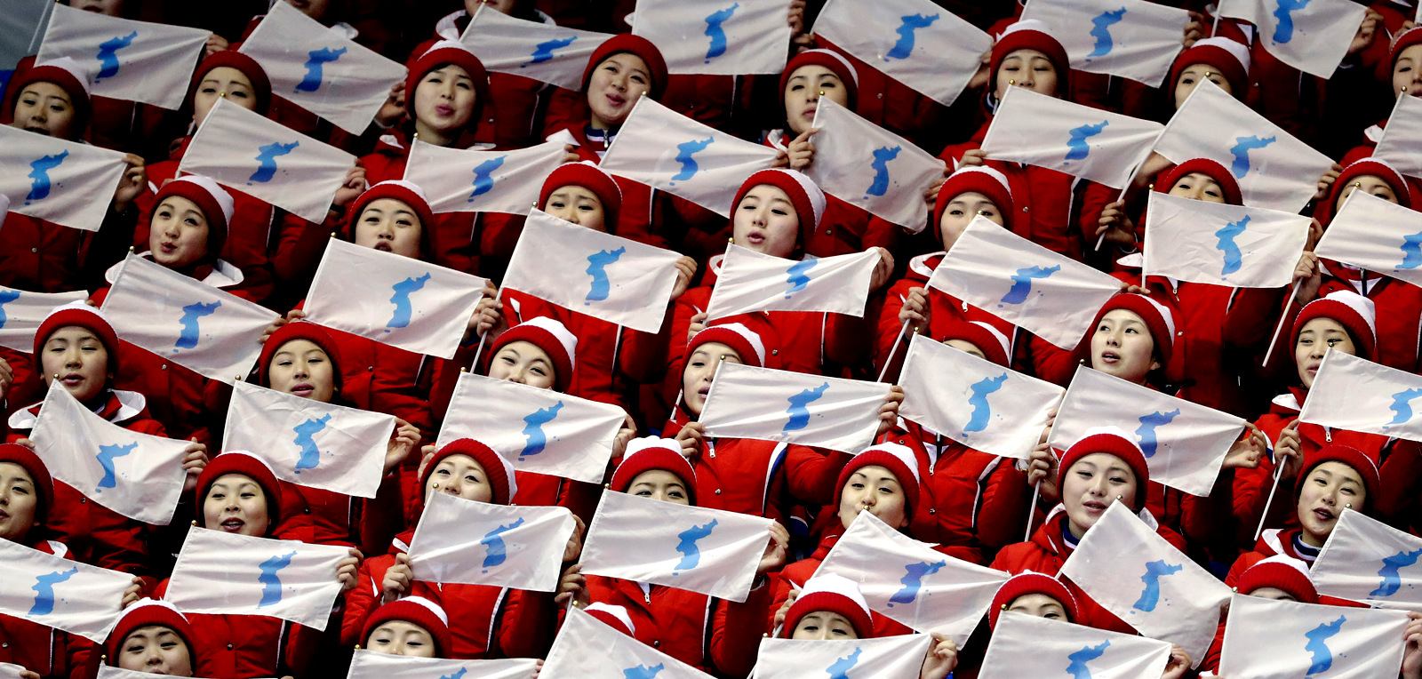 North Korea supporters wave the Korean unification flag ahead of the pairs free skate figure skating final in the Gangneung Ice Arena at the 2018 Winter Olympics in Gangneung, South Korea, Feb. 15, 2018. (AP/Bernat Armangue)