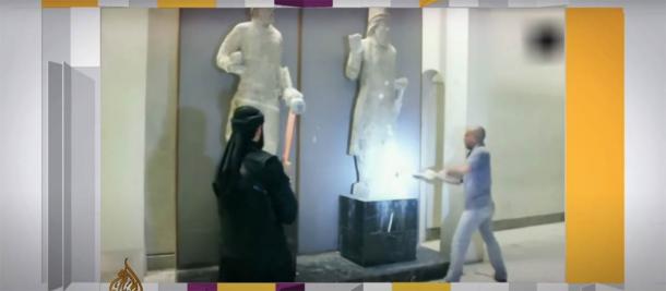 ISIS soldiers in the Museum of Mosul destroying ancient Nineveh artifacts with sledgehammers in 2015. (Aljazeera / Screenshot)
