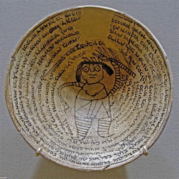 Protective spells on an ancient Jewish occult incantation bowl from the Sassanid Empire. These bowls were buried upside down below the structure of the house or on the land of the house to trap demons. The center of the inside of the bowl depicts Lilith, or the male form, Lilit. Surrounding the image is a spiral form incantation inscribed in Jewish Babylonian Aramaic, Syriac, Mandaic, Middle Persian, and Arabic. (Marie-Lan Nguyen (2011) / CC BY-SA 2.5)