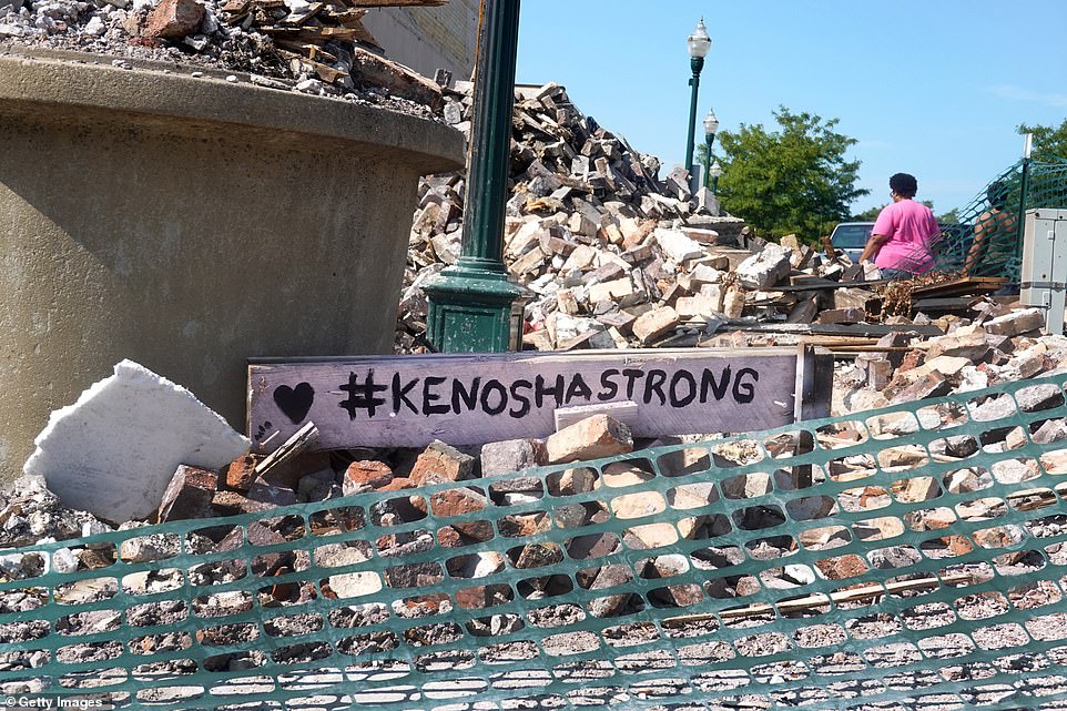 A sign with the phrase '#KenoshaStrong' is seen among the rubble of a building that was burned down during riots that erupted in Kenosha, Wisconsin, following the police shooting of Jacob Blake. The city of 100,000 on the shore of Lake Michigan has been roiled by unrest in the week since 29-year-old Blake, a black man, was left paralyzed from the waist down after he was shot multiple times in the back by police officers in front of his children on August 23