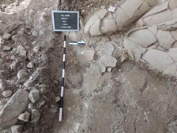 Jars and the floor of the Canaanite palace falling into the trench. (Timothy Pierce)