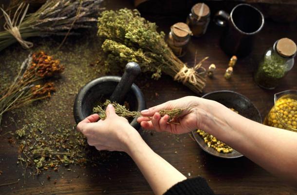 An herbalist at work grinding up and mixing medicinal herbs