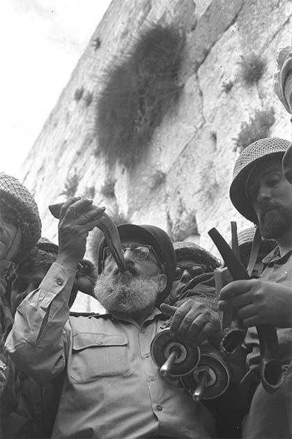 On June 7, 1967, during the Six Day War, Army Chief Chaplain Rabbi Shlomo Goren, surrounded by IDF soldiers, blows the shofar horn in front of the Western Wall in Jerusalem, declaring the Jewish return to the Temple Mount after a two-millennia-long absence. (Government Press Office (Israel)/CC BY SA 4.0)