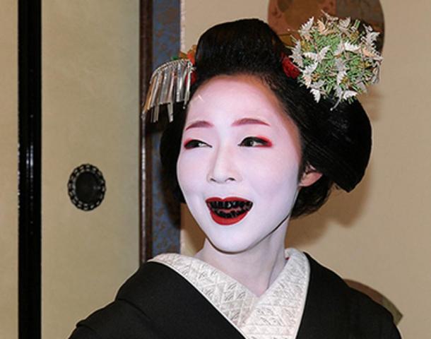 A woman with teeth stained black by the practice of Ohaguro.
