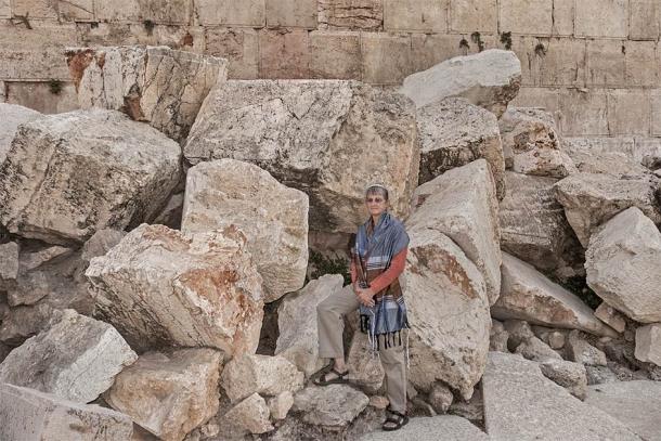 A female rabbi posing on the massive stones thrown down from the Temple Mount by the Romans during the Great Jewish Revolt in Jerusalem where the "cursed" ballista stones were taken from. (Sarit Richerson / Adobe Stock)